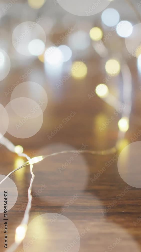 Poster bokeh lights animation over blurred string lights on wooden surface