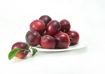 Berries of ripe cherry plum, plum, red color on a white plate, close-up.