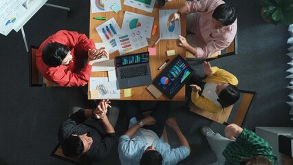 Top down view of business team putting hand together while discussing about Ux Ui design for mobile...