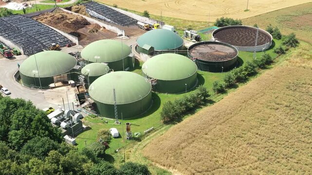 Biogas plant and farm in fields. Renewable energy from biomass. Agriculture prepared for Green Deal. Aerial view to Czech industry. Sustainable development in European Union.	