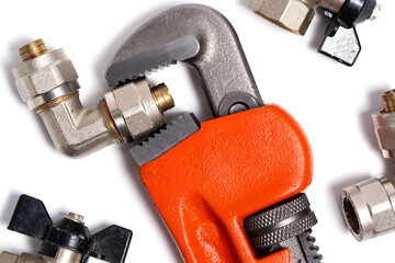 Adjustable wrench and plumbing fittings isolated on white background.