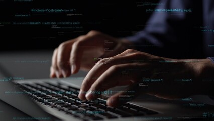 A close-up of hands of a programmer typing on a laptop, with digital code hovering in the air,...
