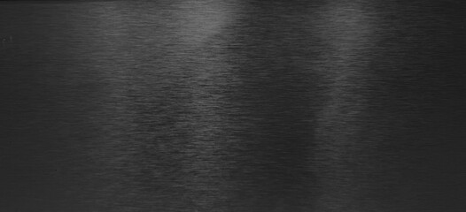 Brushed dark black metal texture with horizontal grain and subtle reflections, ideal for backgrounds, luxurious designs, and industrial aesthetics.