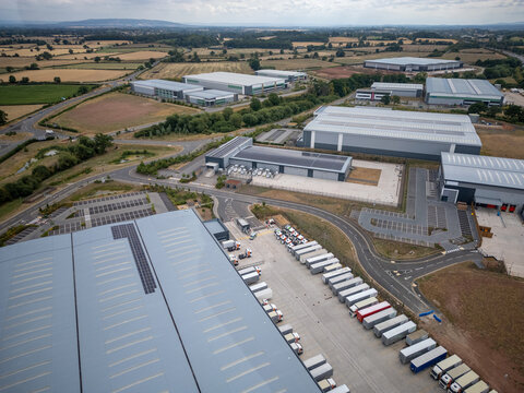 warehouse aerial, UK logistics hub, solar roof, drone industrial, trucking depot, freight facility, commercial warehouse, countryside industry, drone UK, logistics estate, supply chain center, modern 