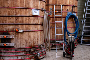 Grandes cuves en bois alignées à l’intérieur d’une installation artisanale ou industrielle...