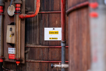 Gros plan sur de grandes cuves en bois alignées à l’intérieur d’une installation artisanale ou industrielle dédiée à la fermentation ou à la production de boissons.