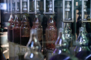 Bouteilles en verre alignées sur une chaîne de production mécanisée dans une usine de fabrication spécialisée.