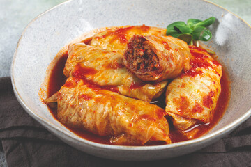 Stuffed cabbage rolls with minced meat, in tomato sauce, top view, without people, in the spotlight.