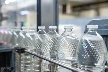 Bouteilles en plastique vides alignées sur une chaîne de production automatisée dans une usine industrielle spécialisée.