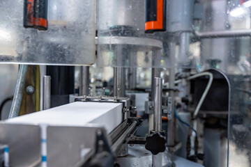 Gros plan détaillé sur une machine de production automatisée en fonctionnement dans une usine industrielle spécialisée.