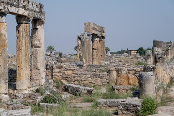 Fototapeta premium Exploring the Ancient Ruins of Pamukkale Showcasing Stunning Columns and Stone Structures Under a Clear Blue Sky