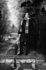 Portrait of a young beautiful long-haired girl in the early winter outdoors. Black and white photo.