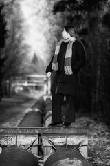 Portrait of a young beautiful long-haired girl in the early winter outdoors. Black and white photo.
