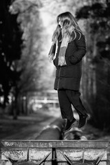 Portrait of a young beautiful long-haired girl in the early winter outdoors. Black and white photo.