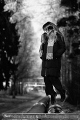 Portrait of a young beautiful long-haired girl in the early winter outdoors. Black and white photo.