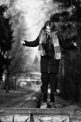Portrait of a young beautiful long-haired girl in the early winter outdoors. Black and white photo.