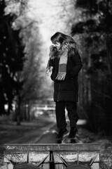 Portrait of a young beautiful long-haired girl in the early winter outdoors. Black and white photo.