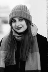 Portrait of a young beautiful long-haired girl in the early winter outdoors. Black and white photo.