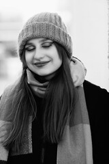 Portrait of a young beautiful long-haired girl in the early winter outdoors. Black and white photo.