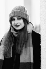 Portrait of a young beautiful long-haired girl in the early winter outdoors. Black and white photo.