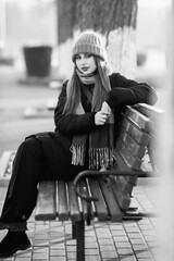 Portrait of a young beautiful long-haired girl in the early winter outdoors. Black and white photo.