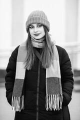 Portrait of a young beautiful long-haired girl in the early winter outdoors. Black and white photo.