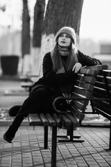 Portrait of a young beautiful long-haired girl in the early winter outdoors. Black and white photo.