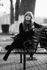 Portrait of a young beautiful long-haired girl in the early winter outdoors. Black and white photo.
