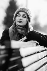 Portrait of a young beautiful long-haired girl in the early winter outdoors. Black and white photo.