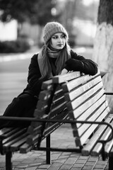 Portrait of a young beautiful long-haired girl in the early winter outdoors. Black and white photo.