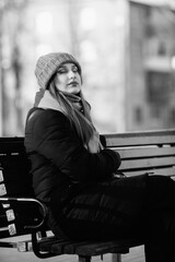 Portrait of a young beautiful long-haired girl in the early winter outdoors. Black and white photo.