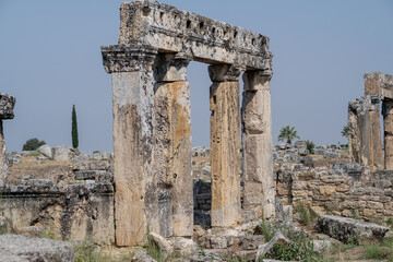 Fototapeta premium Discover the Ancient Ruins of Pamukkale Featuring Striking Columns and Remnants of Historical Architecture Surrounded by Beautiful Nature