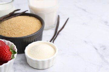 Different ingredients for panna cotta. Milk, sugar, vanilla and strawberries on white marble table, closeup. Space for text