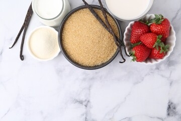 Different ingredients for panna cotta. Milk, sugar, vanilla and strawberries on white marble table, flat lay. Space for text