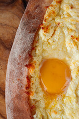 Freshly baked Adjarian khachapuri with beaten egg, traditional Georgian cuisine, homemade, natural light, no people,
