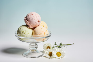Glass bowl of ice cream and fresh flowers.