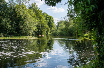Two kayaks float peacefully on the River Lea near Enfield Lock, surrounded by calm water and lush greenery in a tranquil outdoor scene.