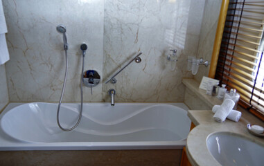 Luxurious marble design bathroom with sink, shower, towels and mirror and mosaic tiles in cabin or...