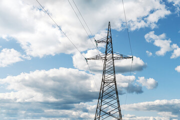 High voltage metal tower with power line wires. Pillar on blue sky.