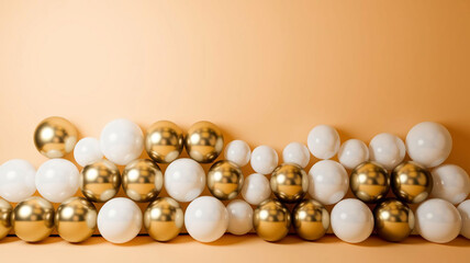 A horizontal array of various sized matte white and glossy gold balloons scattered across the bottom third of the frame, against a plain, soft cream-colored background, with ample copy space above