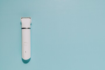 Modern white hair clipper on blue. Perfect for themes of grooming, self-care, and personal hygiene tools.
