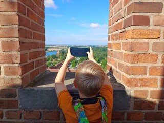 Chłopiec robiący zdjęcie z wieży w Malborku. © EwaAF