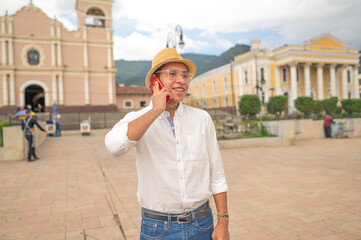 Young Latino man talking on his smartphone. Young Latino tourist in western Guatemala.