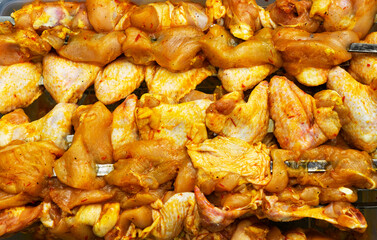 Delicious, alluring, marinated chicken fillet kebabs with large onion rings on skewers are fried on the grill. Picnic and BBQ in summer forest on nature.