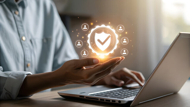 Person using a smartphone and laptop with a glowing digital security shield and user icons symbolizing data protection and online safety