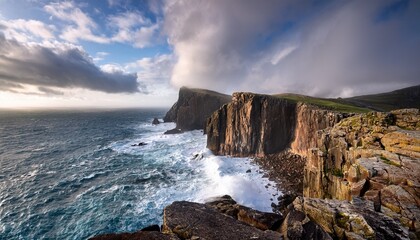 Obraz premium dramatic cliffs overlooking a rocky shore crashing waves cloud cliff