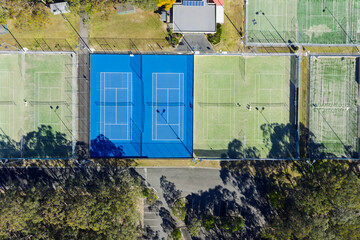 Drone aerial photograph of Tennis Courts located amongst trees and lush natural foliage in the town...