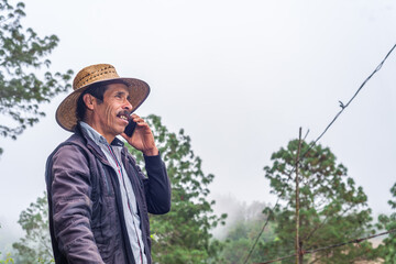 Adult farmer having a telephone conversation using a smartphone.