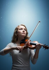 Fototapeta premium Young Woman Playing Violin Against Blue Background
