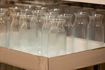 Assorted clear glass jars, stemware and carafes arranged in rows for retail sale